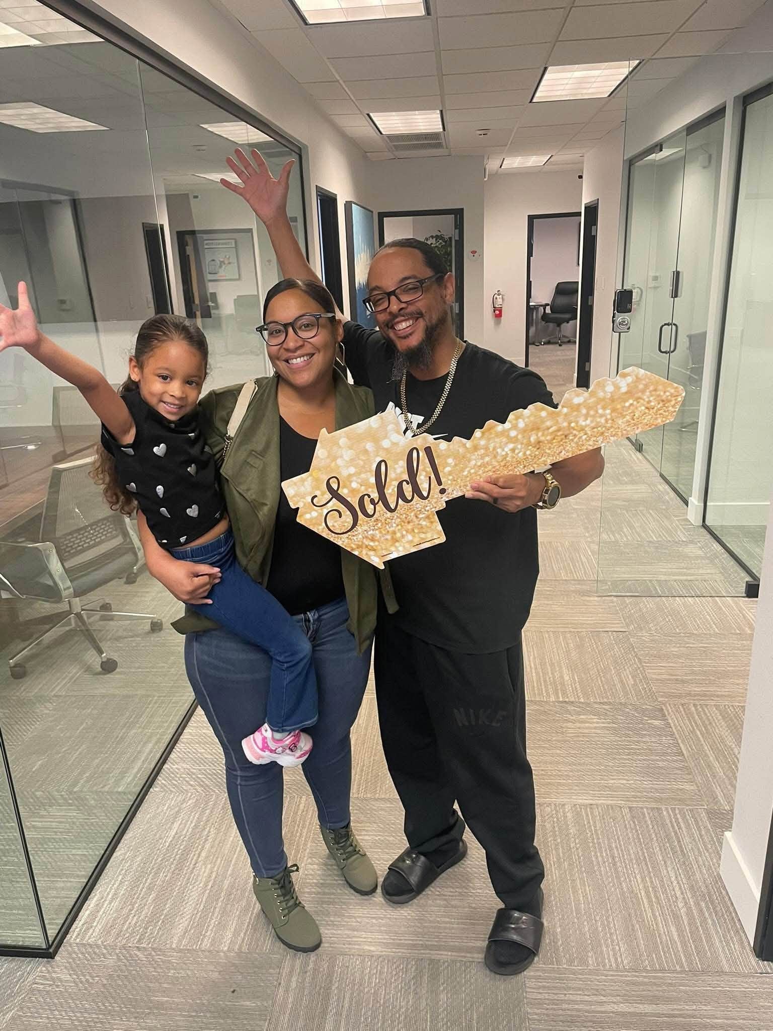 Family celebrating with Sold key after closing with Rita